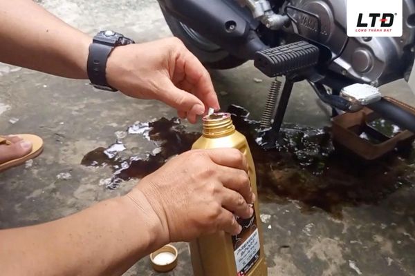 Mở nắp châm dầu và sử dụng phễu để đưa Yamalube vào động cơ