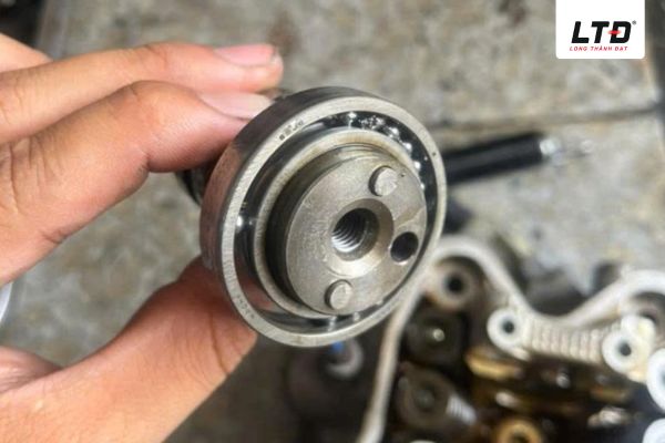 Vòng bi và trục cam có vết dầu đen, hao mòn do ma sát khi thiếu mỡ/nhớt bôi trơn.